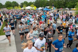 A large crowd of people running the Angels Among Us 5K